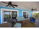 Inviting porch featuring comfortable seating, ceiling fans, blue siding, and sliding glass doors at 9390 Little Gasparilla Island, Placida, FL 33946