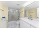 Well-lit bathroom features a single sink vanity, walk-in shower with glass doors, and white tile floors at 101 N Marion Ct # 215, Punta Gorda, FL 33950
