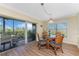 Dining area featuring wood floors, glass table, and sliding glass doors to balcony at 101 N Marion Ct # 215, Punta Gorda, FL 33950