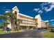 Multi-level condominium with balconies, palm trees, and ample parking on a sunny day at 101 N Marion Ct # 215, Punta Gorda, FL 33950