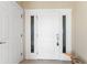 Entry door with sidelights and transom window, complimented by a pelican statue on tiled flooring at 101 N Marion Ct # 215, Punta Gorda, FL 33950