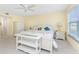 Bright bedroom boasts a ceiling fan, yellow walls, white furniture, and a cozy ambiance at 101 N Marion Ct # 215, Punta Gorda, FL 33950