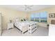 This primary bedroom features ocean views from the window, white furnishings, and a ceiling fan at 101 N Marion Ct # 215, Punta Gorda, FL 33950