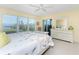 Bright main bedroom with water view features a sliding glass door, ceiling fan and white dresser at 101 N Marion Ct # 215, Punta Gorda, FL 33950