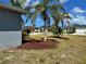 Well-manicured front yard with mature palms and tasteful landscaping, enhancing the property's curb appeal at 1025 Boundary Blvd, Rotonda West, FL 33947