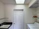 Functional laundry room with skylight, utility sink, storage shelves, and modern washer and dryer for convenience at 1025 Boundary Blvd, Rotonda West, FL 33947