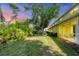 Beautiful backyard featuring green grass, mature trees, and a screened-in patio providing relaxing outdoor living at 1215 Jonah Dr, North Port, FL 34289