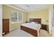 Bedroom with neutral carpet, tray ceiling, and large window for natural light at 1215 Jonah Dr, North Port, FL 34289
