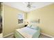 Simple yellow bedroom with a window and light blue bedding and decor at 1215 Jonah Dr, North Port, FL 34289