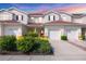 Inviting townhouse showcasing a well-manicured yard, red front doors, and convenient two-car garage at 1215 Jonah Dr, North Port, FL 34289