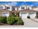 Inviting townhouse showcasing a well-manicured yard, red front doors, and convenient two-car garage at 1215 Jonah Dr, North Port, FL 34289