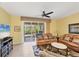 Living room featuring tile floors, ceiling fan, with large sliding glass doors to outdoor space at 1215 Jonah Dr, North Port, FL 34289