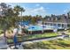 Community pool area with a clubhouse, bocce ball, lounge chairs, and umbrellas, surrounded by trees and grass at 1215 Jonah Dr, North Port, FL 34289
