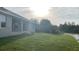 View of the green backyard featuring a lush lawn and a scenic waterfront, with the house and landscaping at 13236 Pace Cir, Port Charlotte, FL 33981