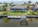 Aerial view of property featuring a dock, boat lift, screened lanai, pool, and canal access at 1330 Mineo Dr, Punta Gorda, FL 33950