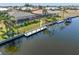 Aerial view of the waterfront home featuring a dock, boat lift, screened lanai, and canal access at 1330 Mineo Dr, Punta Gorda, FL 33950