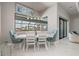 Dining room with a view of the pool through a large picture window. Furnished with a white table at 1330 Mineo Dr, Punta Gorda, FL 33950
