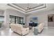 Bright living room featuring a tray ceiling, modern furniture, and access to the outdoor pool area at 1330 Mineo Dr, Punta Gorda, FL 33950