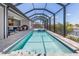 Enclosed pool area with a jacuzzi, a covered seating area, and an outdoor grilling space at 1330 Mineo Dr, Punta Gorda, FL 33950