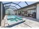 An enclosed pool and jacuzzi are adjacent to a covered outdoor seating area with a table and grill at 1330 Mineo Dr, Punta Gorda, FL 33950
