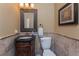 Elegant powder room featuring a carved wood vanity, decorative mirror, and tiled walls at 1367 Grebe Dr, Punta Gorda, FL 33950