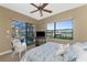 Bright bedroom with ceiling fan, television, and view of the screened-in pool and waterway at 1367 Grebe Dr, Punta Gorda, FL 33950