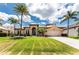 Beautiful single Gathering home featuring a manicured lawn, mature palm trees, and a concrete driveway at 1367 Grebe Dr, Punta Gorda, FL 33950
