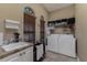 Bright laundry room with a sink, storage cabinets, and modern washer and dryer units for convenience at 1367 Grebe Dr, Punta Gorda, FL 33950