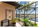 Screened pool area with an outdoor shower and tropical landscaping overlooks the waterfront at 1367 Grebe Dr, Punta Gorda, FL 33950