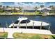 Scenic waterfront view featuring a private boat dock, luxury yacht, and beautiful landscaping, promising a relaxed lifestyle at 1367 Grebe Dr, Punta Gorda, FL 33950