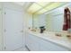 Bright bathroom featuring a sink with white cabinetry and a large mirror at 1374 Grebe Dr, Punta Gorda, FL 33950