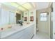 Bright bathroom featuring a double vanity with white countertops and cabinetry, complemented by a well-lit mirror at 1374 Grebe Dr, Punta Gorda, FL 33950