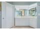 Well-lit bathroom features a double vanity and ample mirror space, with classic white cabinetry and neutral decor at 1374 Grebe Dr, Punta Gorda, FL 33950