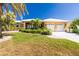 Beautiful home exterior featuring lush landscaping, a two-car garage, and a welcoming entrance at 1374 Grebe Dr, Punta Gorda, FL 33950