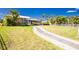Well-manicured front lawn and landscaping leads to the home's entrance and screened in lanai at 1374 Grebe Dr, Punta Gorda, FL 33950