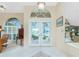 Bright foyer featuring tiled floors, arched transom windows and decorative glass double doors at 1374 Grebe Dr, Punta Gorda, FL 33950