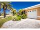 Well-maintained home featuring a two-car garage, mature landscaping, and a concrete driveway at 1374 Grebe Dr, Punta Gorda, FL 33950