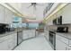 Open kitchen boasts white cabinets, stainless appliances, granite counters, and abundant natural light at 1374 Grebe Dr, Punta Gorda, FL 33950