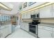 Well-lit kitchen with white cabinets, granite countertops, and stainless steel appliances at 1374 Grebe Dr, Punta Gorda, FL 33950