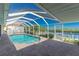 A screened in pool area with brick flooring and lush landscaping at 1374 Grebe Dr, Punta Gorda, FL 33950