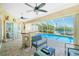 Screened-in pool area featuring outdoor seating, a bar, and waterfront views at 1374 Grebe Dr, Punta Gorda, FL 33950