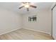 Neutral bedroom boasts hardwood floors, ceiling fan, and screened window with natural light at 1510 Orlando Blvd, Port Charlotte, FL 33952