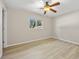 Bright bedroom with ceiling fan, light wood floors, and a window with natural light at 1510 Orlando Blvd, Port Charlotte, FL 33952