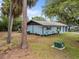 Exterior view of the home with a spacious yard and mature palm trees at 1510 Orlando Blvd, Port Charlotte, FL 33952