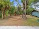 Exterior view of the home showing the spacious yard with mature trees at 1510 Orlando Blvd, Port Charlotte, FL 33952