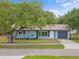 Charming single-story home with a well-manicured lawn, mature trees, and a cozy front porch at 1510 Orlando Blvd, Port Charlotte, FL 33952