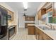 Kitchen with wooden cabinetry, stainless steel appliances, and a view of the adjacent living space at 1510 Orlando Blvd, Port Charlotte, FL 33952