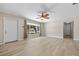Open living room with light wood floors, ceiling fan, and a view to the front yard at 1510 Orlando Blvd, Port Charlotte, FL 33952