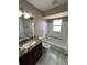 Well-lit bathroom with modern vanity, toilet, and tiled shower-tub at 16072 Galiano Ct, Punta Gorda, FL 33955