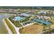 Community aerial view showcasing a resort-style pool, clubhouse, pickleball courts and bocce ball at 16079 Bandermill Dr, Port Charlotte, FL 33953